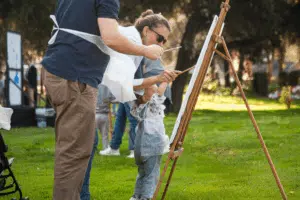 Familia pintando un cuadro en la muestra de artes